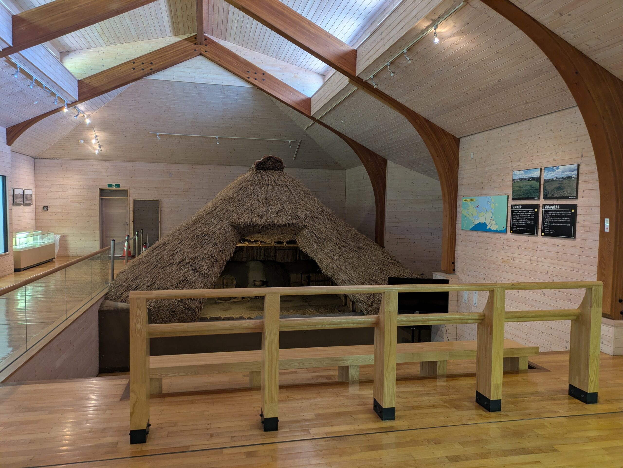 展示室の全景|暮らしの記憶にふれる入口 北斗遺跡展示館の展示室入口から見た復元住居の全体像。